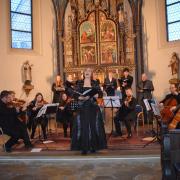 Im Vordergrund ist Solistin Annika Hausmann zu sehen - gemeinsam mit dem Ensemble „Musica fiorente“ der Pfarrei St. Martin Lauingen und Sängerinnen und Sänger des Gesangsstudios Miriam Galonska. 