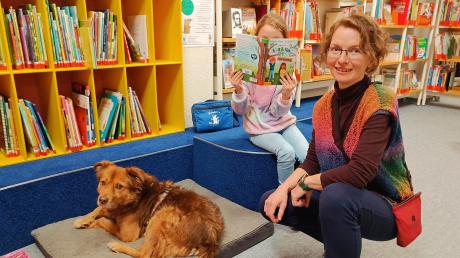 An seinem Arbeitsplatz: Hund Milo mit der siebenjährigen Paula und Büchereileiterin Hildegard Häfele in Königsbrunn.