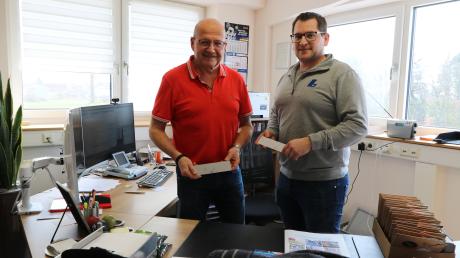 Geschäftsführer Günter Lämmermeier und Technischer Leiter Thomas Strobel, sie halten Heizkörperabdeckungen aus spiegelpoliertem Edelstahl, welche die Firma fertigt. 