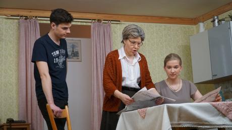 Michi (Christoph Pschor) Traudl Mosacher (Antonia Bichler) und Oma (Andrea Keller) lesen Zeitung, um auf dem neuesten Stand zu sein.