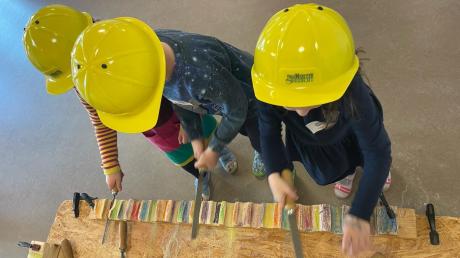 Die Vorschulkinder des Wertinger Kinderhauses sind an der Feil-Station mit vollem Einsatz dabei. Mit Feilen und Raspeln arbeiten sie Vertiefungen in das Holz. 