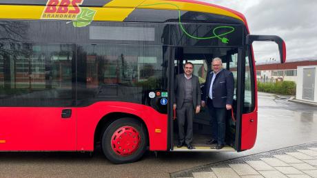 Stolz zeigt Josef Brandner dem CSU-Fraktionsvorsitzenden im Bayerischen Landtag, Klaus Holetschek, einen der ersten batterie-elektrisch betriebenen Gelenkbusse.