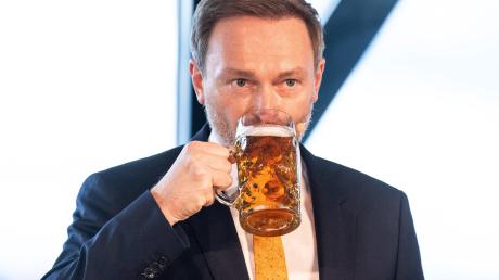Der FDP-Bundesvorsitzende Christian Lindner trinkt beim Politischen Aschermittwoch der Liberalen ein Bier. 