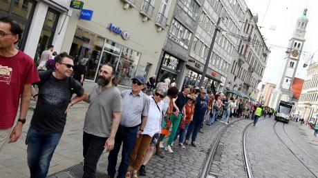 Rund 400 Menschen setzten am Sonntag mit einer Menschenkette in Augsburg ein Zeichen für Demokratie, Frieden und gegen Faschismus.              