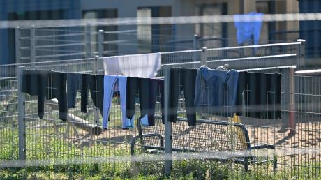 Die schwierige Balance zwischen dem Schutz Verfolgter und der Überlastung der Aufnahmeländer. Wäsche hängt zum Trocknen über einem Zaun auf dem Gelände einer deutschen Erstaufnahme-Einrichtung.