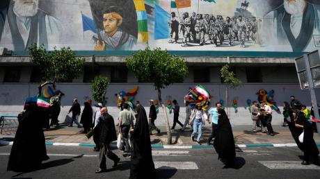  Iranische Gläubige gehen an einem Wandgemälde vorbei, das den verstorbenen Revolutionsgründer Ayatollah Khomeini zeigt. Wie weit kann der Konflikt im Nahen Osten eskalieren? 