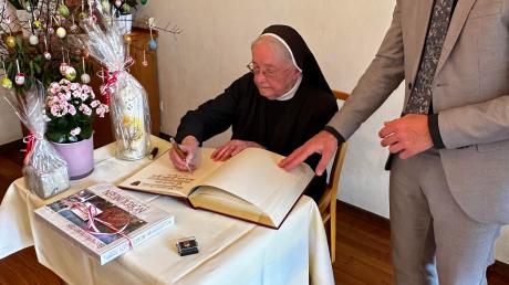 Schwester Josefine trägt sich ins Goldene Buch der Stadt Nördlingen ein.