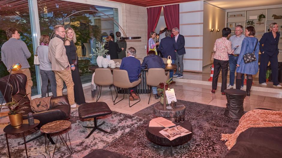 Von Poll Immobilien hat rund 200 Gäste zu einer Party in eine leer stehende Luxusimmobilie in Augsburg-Göggingen eingeladen. Das große Wohnzimmer mit Leseecke war ein beliebter Treffpunkt.