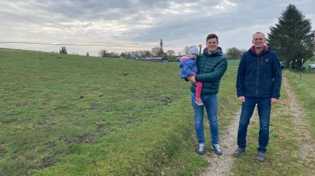 Erich Klas (rechts, mit auf dem Bild sind sein Neffe Michael und dessen Tochter) will auf einer Grünlandfläche westlich von Hechenwang (Hintergrund) eine Agri-PV-Anlage errichten.