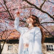 Christina Kling posiert vor einem blühenden Kirschbaum.