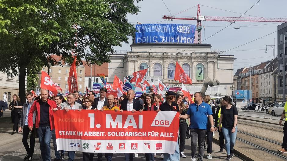 Mehr als 1000 Menschen gehen am 1. Mai bei Kaiserwetter in Augsburg auf die Straße, um für mehr Lohn, Sicherheit und Freizeit zu kämpfen.