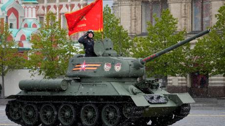 Ein sowjetischer T-34-Panzer mit roter Flagge rollt während der Militärparade zum Tag des Sieges in Moskau.