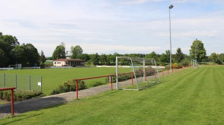 Der TSV Aindling will die Bewässerung zweier Fußballplätze sanieren und ein Feld begradigen. Links im Bild ist das ehemalige Hauptspielfeld, im Hintergrund das ehemalige Sportheim, das der Schützen- und der Musikverein Aindling gerade renovieren. Im Bildvordergrund (rechts) ist das Trainingsgelände mit Toren und Flutlicht zu sehen.