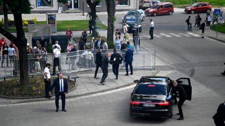 Leibwächter bringen den slowakischen Ministerpräsidenten Robert Fico in einem Auto in Sicherheit. Fico war nach einer Kabinettssitzung in der Stadt Handlova angeschossen und verletzt worden. 