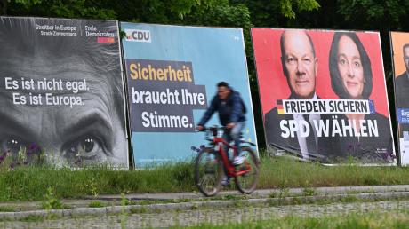 Ein Radfahrer fährt an Wahlplakaten zur Europawahl vorbei.