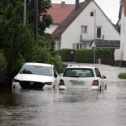 Autos stehen im Hochwasser der Mindel in einem Wohngebiet in Offingen.