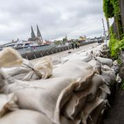 Ein Uferweg in Regensburg ist mit einer mobilen Hochwasser-Schutzwand gesichert, Sandsäcke liegen bereit. Die Donau ist bereits weit über die Ufer getreten.