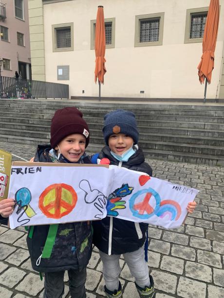 Anton (links) und Pietro (Rechts) von der Bischoff-Ulrich Grundschule haben eigene Schilder gemalt, um ein Zeichen für den Frieden zu setzen.