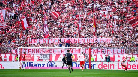 Die Bayern halten ein Transparent mit der Aufschrift «Wir entschuldigen und für die Tennisbälle in Heidenheim, Uli!» in die Luft.