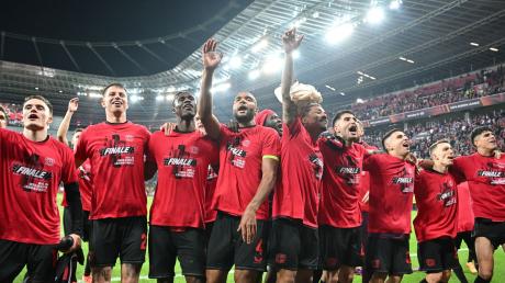 Leverkusens Spieler feiern mit den Fans nach der Partie.