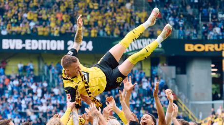 Bierspendende BVB-Legende: Dortmunds Marco Reus wird nach dem Spiel von seinen Mitspielern gefeiert.