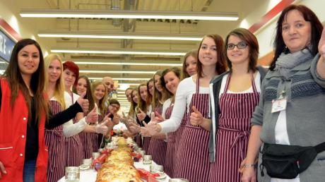 Geschafft: Schülerinnen der St.-Bonaventura-Realschule und Mitarbeiter der Bäckerei Ihle und der Kaufland-Filiale in Dillingen präsentieren Bayerns längsten Hefezopf. 
