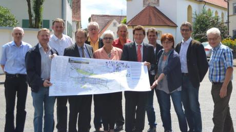 Bachhagels Bürgermeisterin Ingrid Krämmel und einige Gemeinderäte zeigen Johann Huber und Landtagsabgeordneten Georg Winter ihre Pläne für die Dorferneuerung von Bachhagel.  
