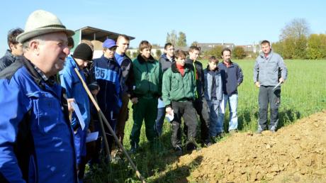 Ulrich Mayerle (links) traf sich mit Schülern der Berufsschule auf seinem Feld, um ihnen Details seines Bodens zu erläutern.