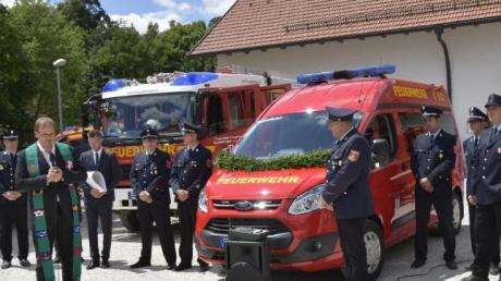 Pfarrer Axel Schmidt (links vorne) gibt dem neuen Mannschaftswagen und den Feuerwehrleuten aus Haunsheim, die damit unterwegs sind, seinen Segen..