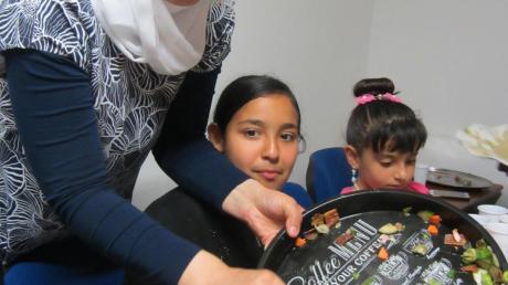 Den Flüchtlingen bleibt oftmals nur die eigene Kultur. Auch bei fünf Familien aus Syrien, die jetzt in Lutzingen wohnen, wird die Gastfreundschaft großgeschrieben. Hier serviert Zainab Alharbi leckere syrische Gerichte. 	