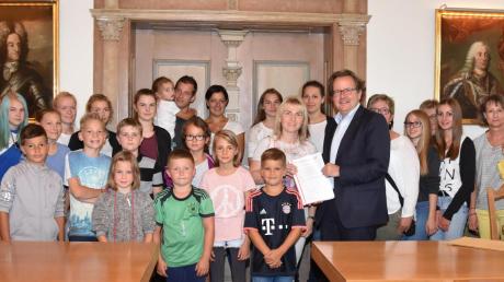 Eltern, deren Kinder die täglich von Bissingen nach Donauwörth zur Schule fahren, wehren sich gegen den neuen Fahrplan. Deswegen überreichten sie Donauwörths Oberbürgermeister Armin Neudert (Mitte) 1305 Unterschriften.  	