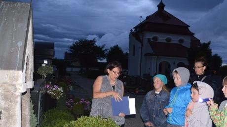 Michaela Thomas zeigt Kindern das Grab und Werke der bekannten Höchstädter Pferdemalerin Inge Ungewitter. 