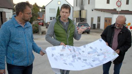 Die beiden Diplomingenieure Beckert (links) und Kimmerle (Mitte) erklären den Gemeinderatsmitgliedern anhand eines Plans den aktuellen Sachstand bei den Tiefbaumaßnahmen in der Ziegeleistraße und Am Anger in Finningen. 