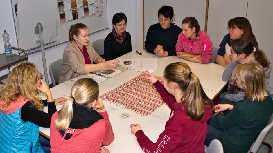 Leonie Schoplocher und Elisabeth Decker (hinten von links) erklären den Studierenden der Wertinger Hauswirtschaftsschule, auf was sie beim Anfertigen von Tischläufern achten müssen. Dabei spielt auch die Nachhaltigkeit eine wichtige Rolle.