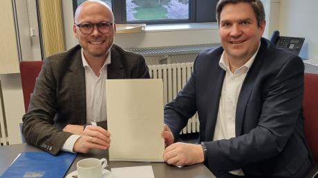 Minister Fabian Mehring (links) hat Landrat Markus Müller für die Digitalisierung des Dillinger Landratsamts einen Förderscheck in Höhe von 20.000 Euro übergeben. 