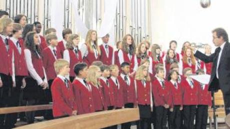 Der Konzertchor der Münchner Chorbuben und Chormädchen wird mit 40 jungen Sängerinnen und Sängern in Rain gastieren. Das Bild zeigt den Chor bei einer Probe in einer Kirche mit seinem Leiter Bernhard Reimann.  