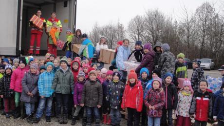 Über 200 Kinder haben sich bei der Firma Zott in Mertingen versammelt und dabei geholfen, einen Lastwagen mit Päckchen zu beladen.  
