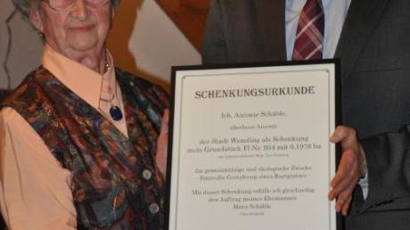 Antonie Schäble überreicht die Schenkungsurkunde für das Grundstück an den Wemdinger Bürgermeister Martin Drexler.  
