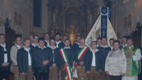Nach einem Gottesdienst stellten sich Mitglieder des Burschenvereins, Pfarrer Wolfgang Woppmann und Ehrengäste zum Gruppenfoto mit der Fahne. 	