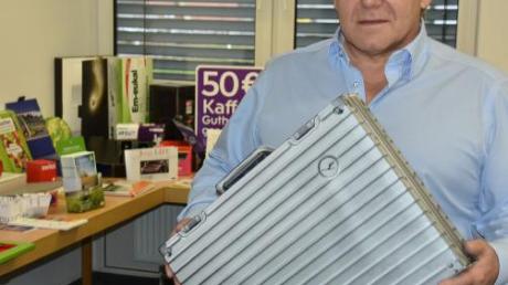 Firmenchef Johann Schmid mit einem Koffer aus Pappe. Der dient Lufthansa für Werbezwecke.