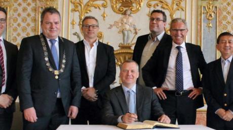 Bürgermeister Martin Scharr (links) begrüßte das Elanders-Management um Präsident Magnus Nilson (am goldenen Buch).  	