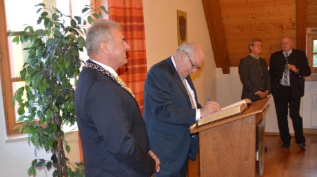 Günther Beckstein hat sich zur Freude von Oberndorfs Bürgermeister Hubert Eberle (vorn) ins Goldene Buch der Gemeinde eingetragen. 