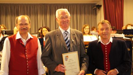 Der stellvertretende Präsident Theo Keller (rechts) und Dirigent und Vorsitzender Anton Böswald (links) gratulieren Stefan Dums zur Fördermedaille des ASM in Silber. 