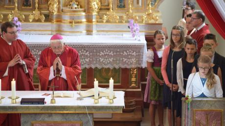 Das Sakrament der Firmung spendete der emeritierte Bischof Walter Mixa (am Altar). Rechts: einige der Firmlinge beim Verlesen der Fürbitten.  	
