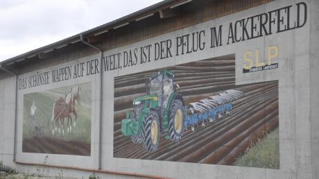Zurückgesetzt von der Bundesstraße 16 ließ Getreidehändler Michael Sailer an der Ortseinfahrt nach Donaumünster eine kahle Betonwand von einer Fassadenmalerin verschönern.