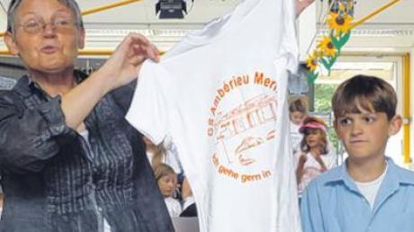 Luise Kleinlein zeigt die neuen Schul-T-Shirts, die der Drittklässler Aljosha entworfen hat. Die T-Shirts sind ein Abschiedsgeschenk der Rektorin an ihre Schüler. 