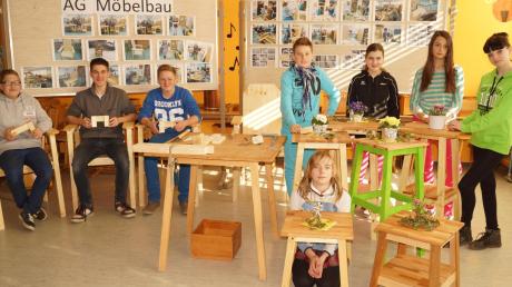Die Arbeit hat sich gelohnt: Stolz thronen die Schüler der Möbel AG von der Mittelschule Merching auf ihren selbst gemachten Stühlen – und auch die Tischchen sind besonders gut gelungen. 
