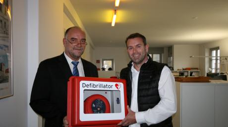 MedX5-Geschäftsführer Volker Brand (links) überreicht Architekt Christian Fußner den neuen Defibrillator des Architekturbüros Fußner und Kühne.