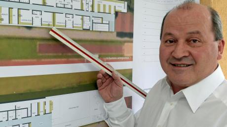 Der 1. Vorsitzende des SV Mering, Gemeinderat Georg Resch (CSU), zeigt mit einem Lineal auf erste Planentwürfe für ein neues Sportheim. 