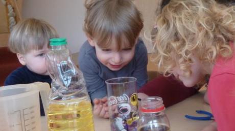 Wasser mit Öl und Farbe – die Kinder beobachten fasziniert, was sich tut.